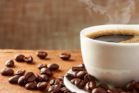 Kaffeetasse mit Kaffeebohnen auf Tisch